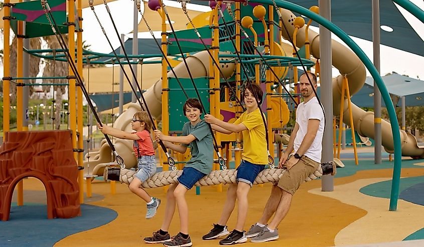 Happy children, boys, playing on playground in Tel Aviv, israel on a hot summer day