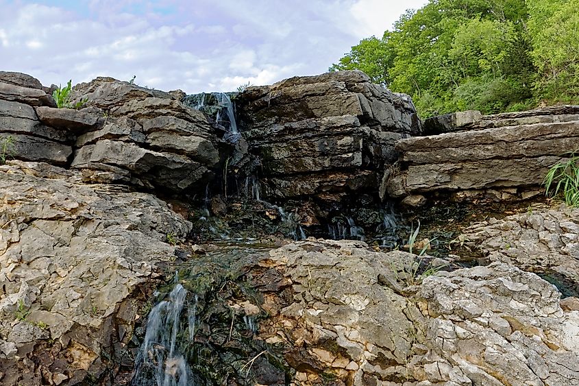 Water rushes over the Lake MacBride waterfall.