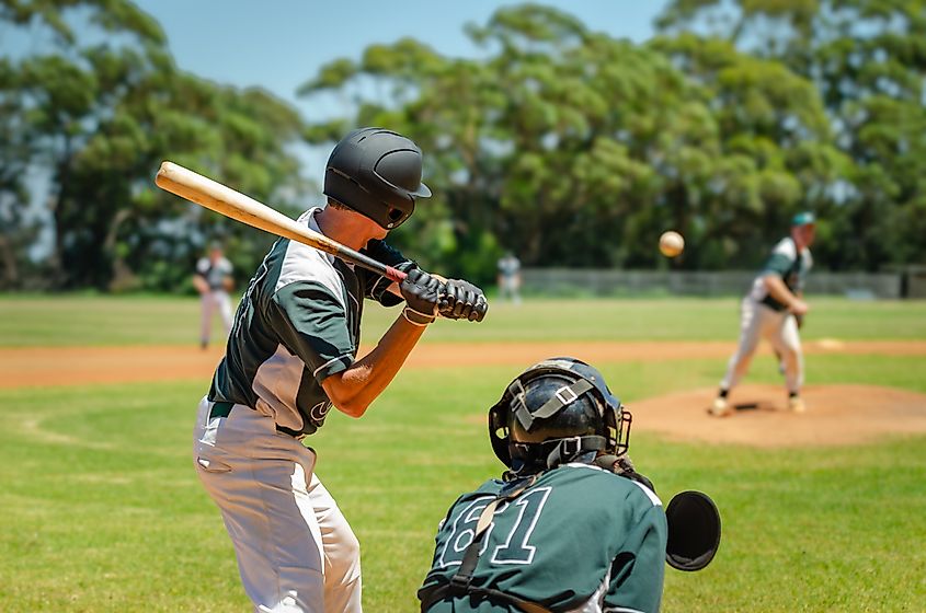 Batter getting ready to hit a pitch during ballgame on a baseball diamond, field.