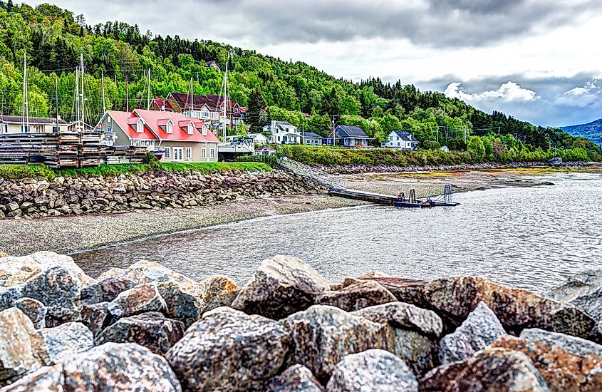 Riverfront houses in L'Anse-Saint-Jean, Quebec, with the Saguenay Fjord in the background