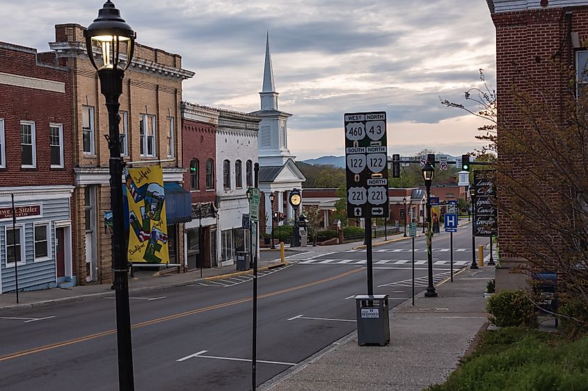 Downtown Bedford, Virginia street with historic buildings, church steeple, and road signs.