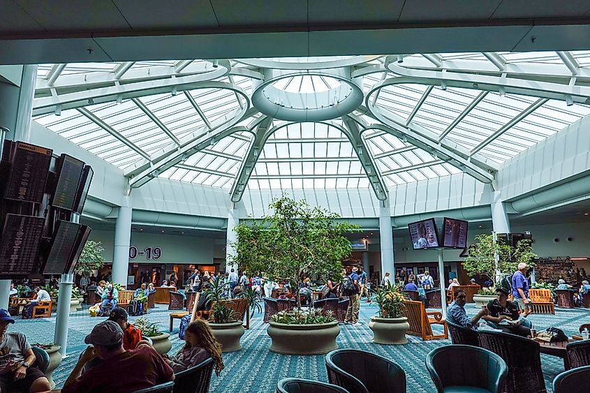 People waiting in an atrium area of the airport for their flights at Orlando International Airport