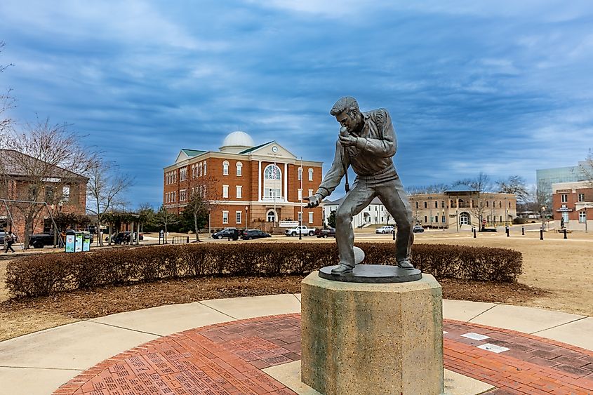 Elvis Presley Statue in Tupelo, MS, with City Hall in the background. Editorial credit: Chad Robertson Media / Shutterstock.com