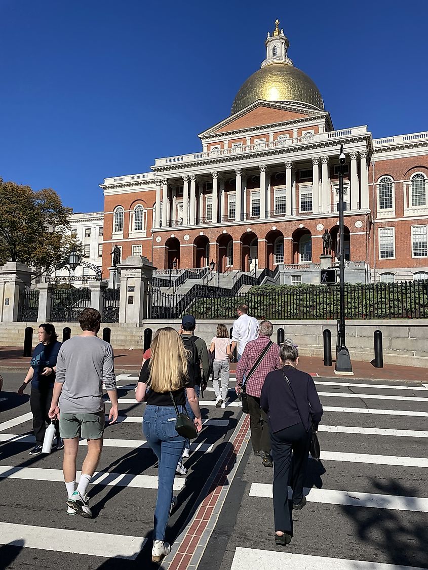 A group of people, following the Freedom Trail, cross the street and head towards the Massachusetts State House in Boston. Editorial credit: James Kirkikis / Shutterstock.com