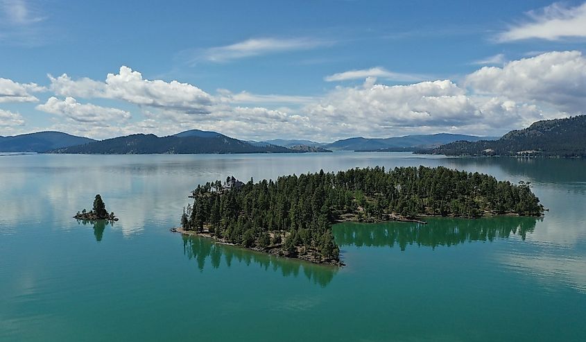 Aerial view of islands and distant mountains in Flathead Lake, Montana on calm summer morning.