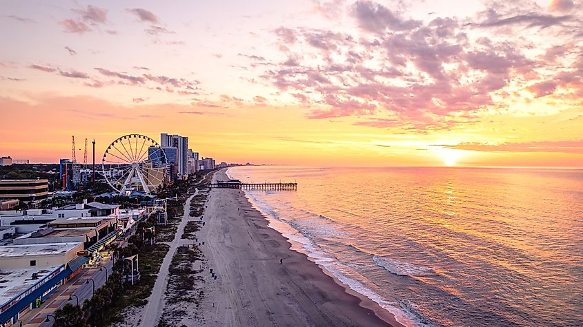 Myrtle Beach, South Carolina at sunrise, with soft light illuminating the ocean, sandy shoreline, and the distant pier.