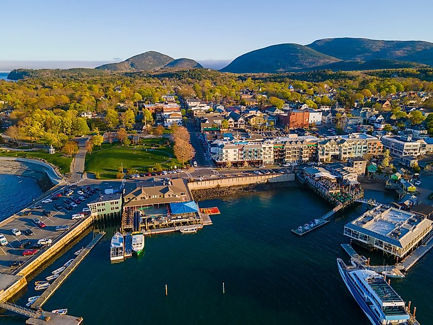 Historic town center aerial view at sunset, with Cadillac Mountain in Acadia National Park at the background, Bar Harbor, ME.