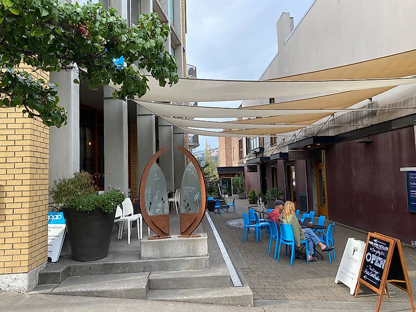 A couple drinks their morning coffee at a pedestrian alleyway table
