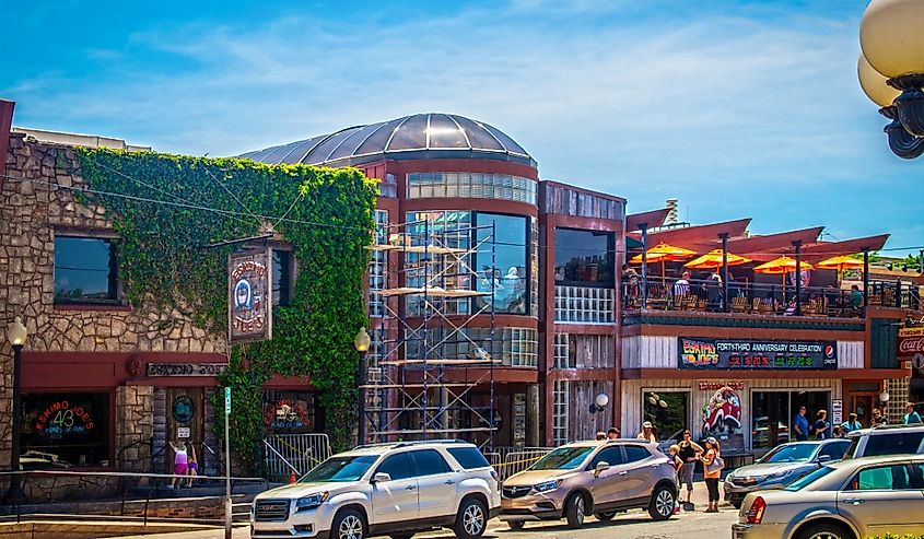 Stillwater USA - Eskimoo Joes resturant and bar under construction with people standing out front and eating on balcony near Oklahoma State University on bright sunny day