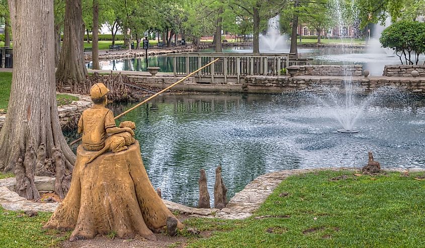 Boy and Dog Fishing Sculpture at Theta Pond on the campus of Oklahoma State University., Stillwater, Oklahoma.