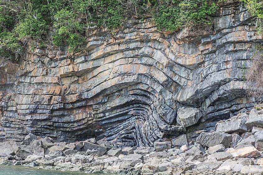 Layered rock formation folds on Thailand bay