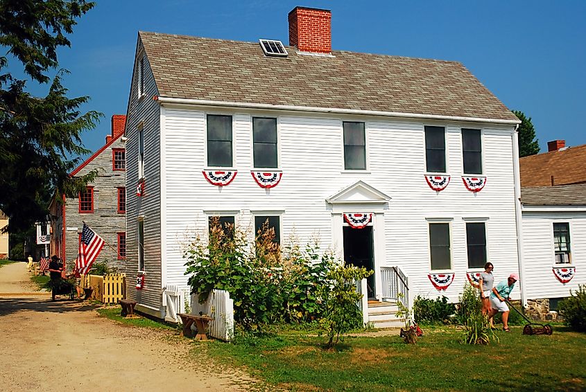 The white colonial Shapiro house is decorated for the Fourth of July with American flags and bunting in the Strawberry Banke section of Portsmouth, New Hampshire. Editorial credit: James Kirkikis / Shutterstock.com