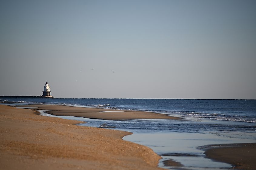 The serene beach with the lighthouse in the distance in the Cape Henlopen State Park, Delaware