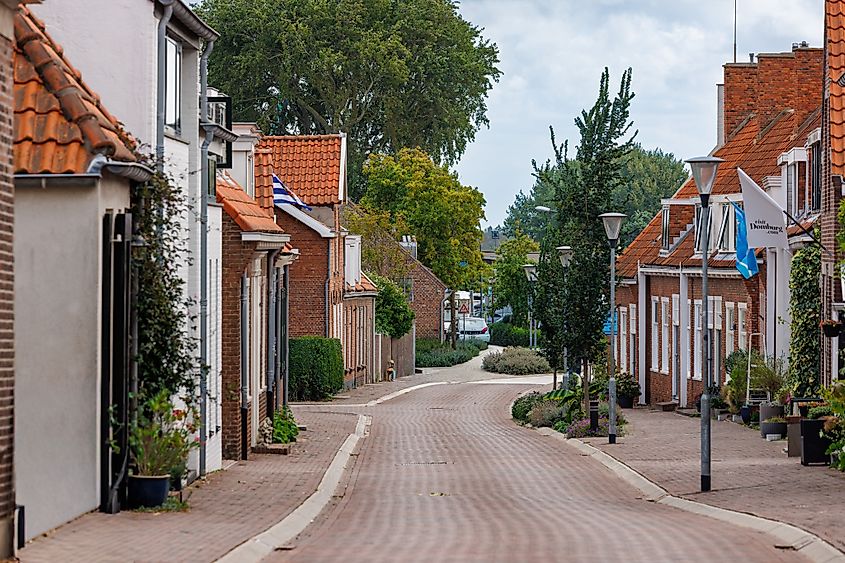 Picturesque street with brick houses and Dutch flags in the center of Domburg.