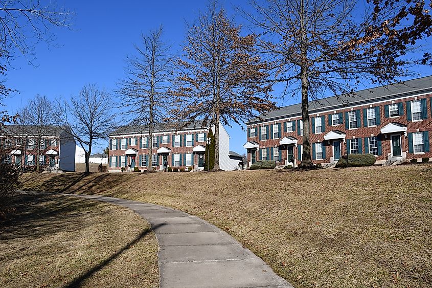 A sidewalk going by large brick houses in a residential area in O'Fallon, Missouri.