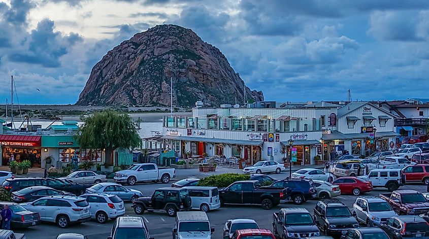 Pier shops and parking lot facing Morro Rock in Morro Bay, California. Editorial credit: shuttersv / Shutterstock.com