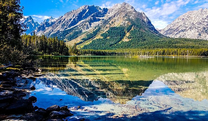 Teton mountains are in full view across Leigh Lake in Grand Teton in Wyoming.