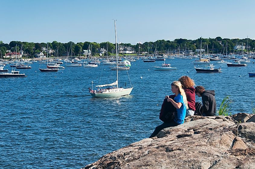 Salem, Massachusetts: Three women sitting on a rock overlooking a harbor. Image Credit Dan Hanscom via Shutterstock.