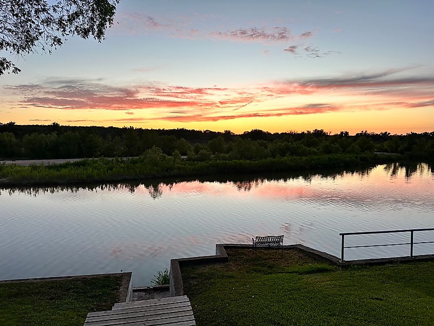 A gorgeous sunset casts warm hues of orange, pink, and purple over the Llano River in Kingsland, Texas.