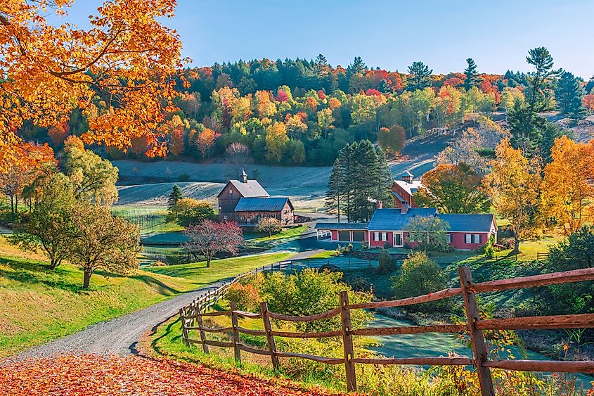 Early autumn foliage scene with houses in Woodstock, Vermont mountains.