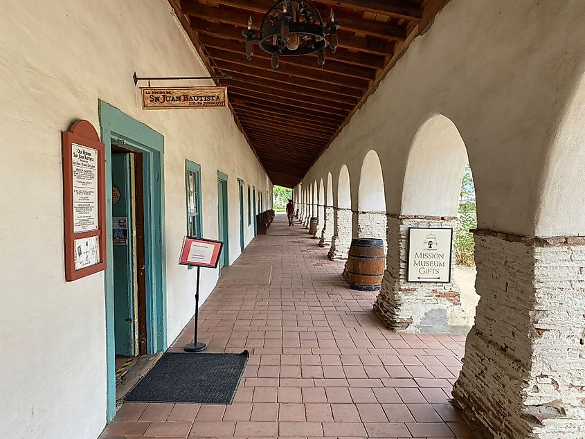 A man walks a long corridor in one of California's old Spanish missions.