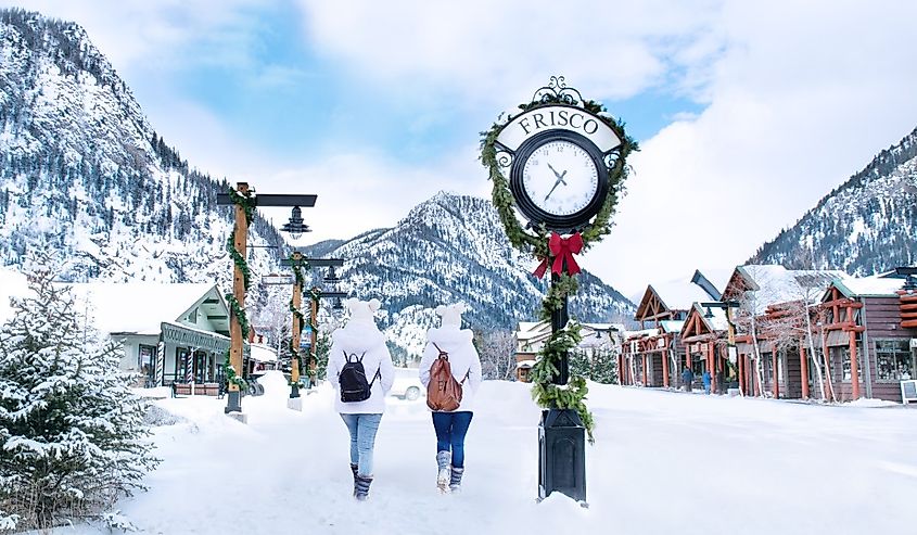 People walking in downtown Frisco, Colorado past the clock in winter.