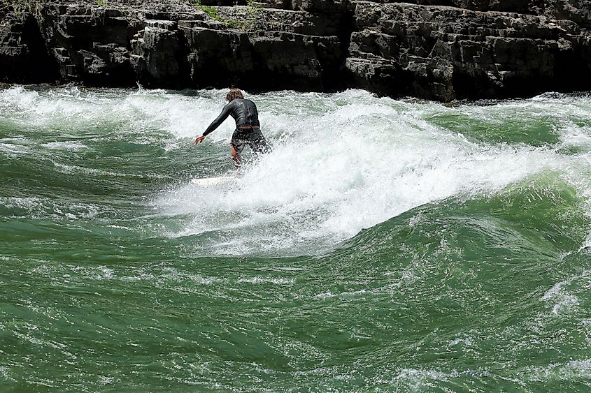 A surfer rides the rapids on the Snake River in Alpine, Wyoming.