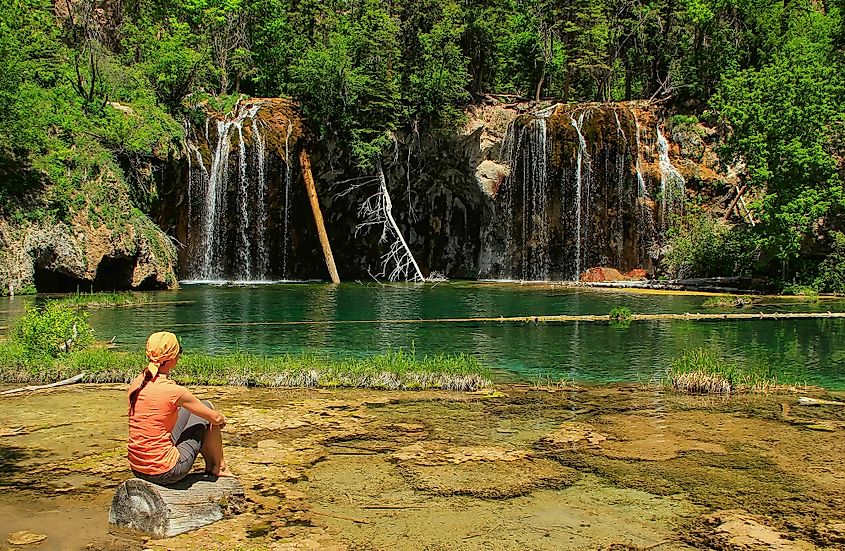 A hiker sitting peacefully at Hanging Lake.