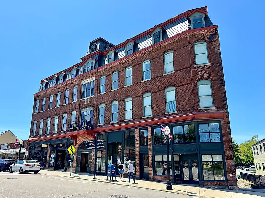 Streetscape of the five-story Martin House, a former hotel in historic downtown Westerly, Rhode Island. Built in 1888, the red brick building features large windows.