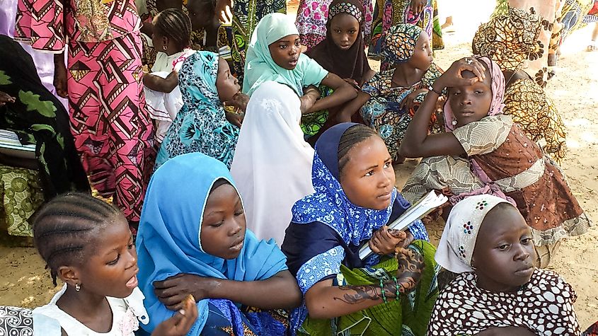 Muslim school girls getting protection from the extreme heat in Niger under a shadow of a tree, outside of their school. Shutterstock/E Pasqualli