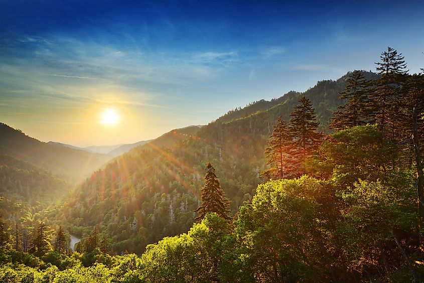 Sunset at Newfound Gap in the Great Smoky Mountains, with vibrant hues casting over the rolling peaks and valleys.