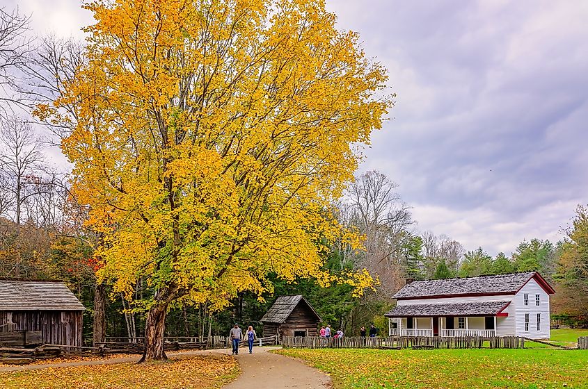 A couple walks past the Gregg-Cable House at the John P. Cable Mill Complex in Great Smoky Mountains National Park.