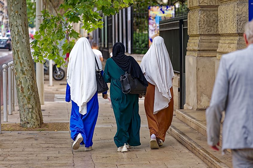 Rear view of three young Muslim women in traditional abaya clothing in Toulon, France. Image Credit Michael Derrer Fuchs via Shutterstock.