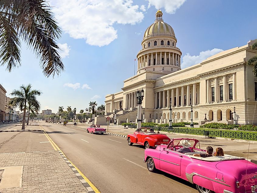 Havana, Cuba -  Street view of vintage convertible cars driving in front of El Capitolio. Source: Shutterstock