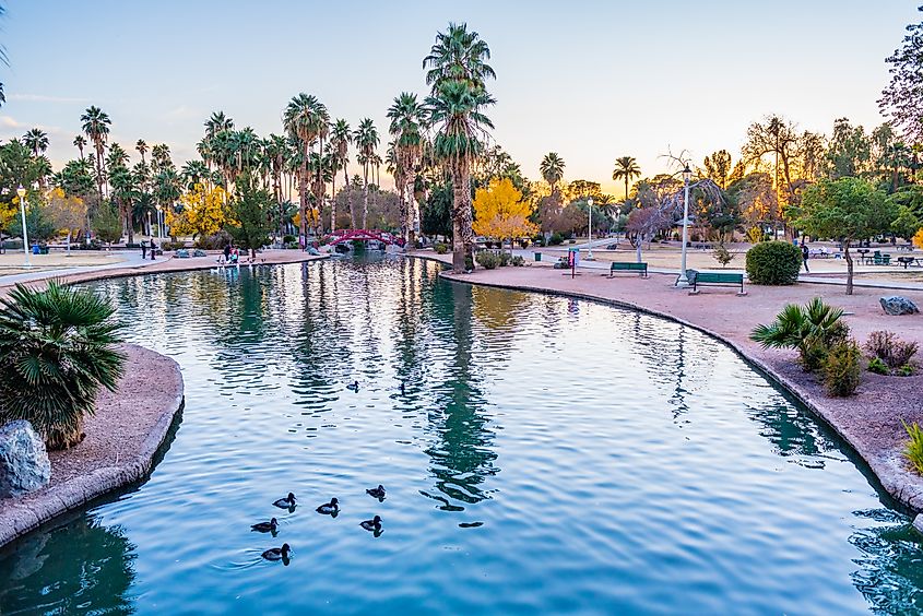 Canal in Encanto Park in Phoenix, Arizona, at sunset with calm water reflecting the evening sky