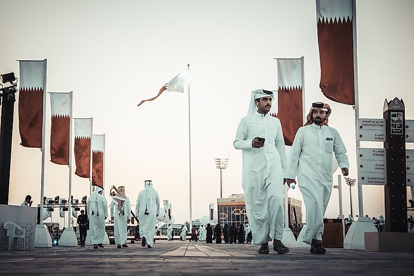 Qatari men walking in Doha, Qatar. Image Credit Damitha Rukshan via Shutterstock.