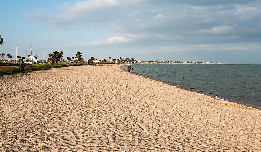 People walk along the sandy beach at Rockport, Texas