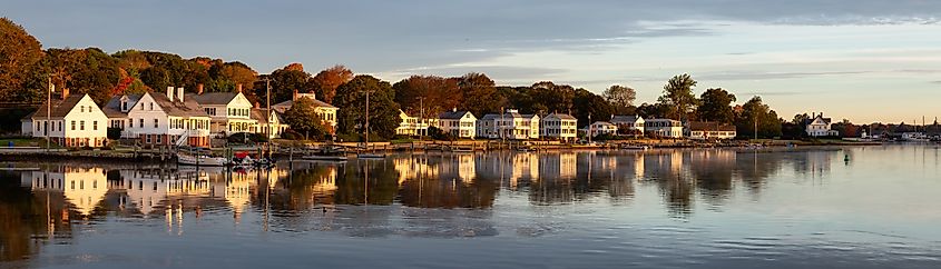 Panoramic view of residential homes by the Mystic River during a vibrant sunrise. 