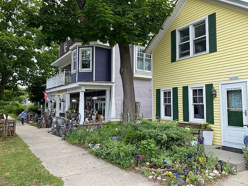 Fresh cream-yellow and royal blue houses surrounded by greenery. 