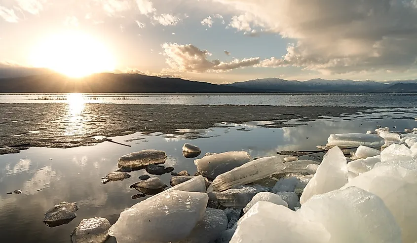 Ice stacks in horizontal image at Vineyard Beach on Utah Lake in Utah at sunset.