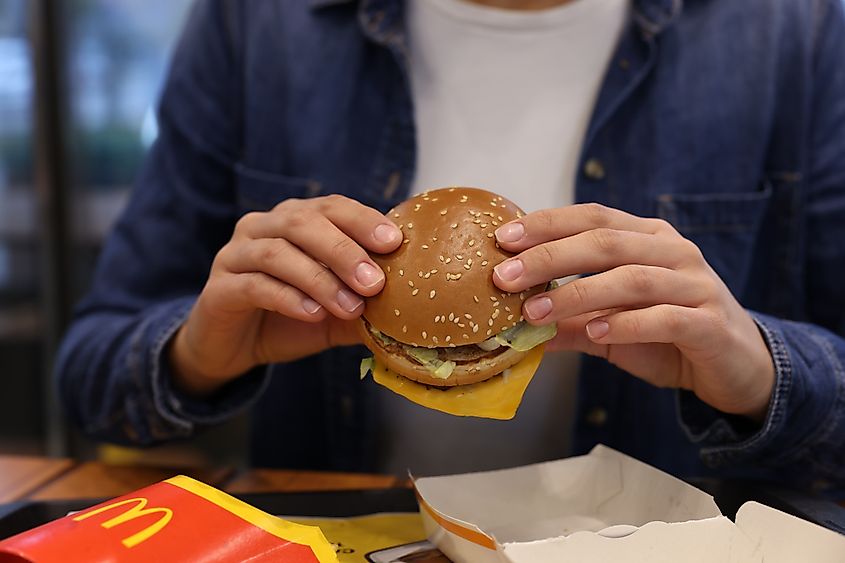 Woman with McDonald's burger at table in restaurant