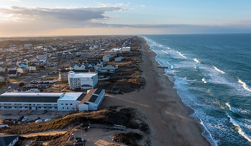 Aerial view of Kill Devil Hills, North Carolina, looking northward along the shoreline, displaying the town's layout against the backdrop of the Atlantic Ocean