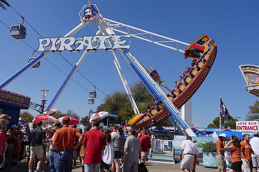 People fall in line to ride the Pirate Boat at the Texas State Fair carnival grounds in Dallas.