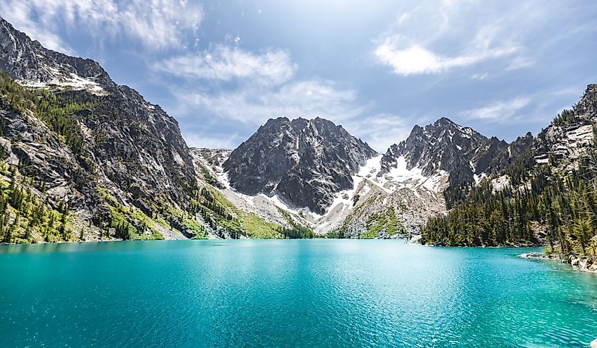 A scenic view of the Colchuck Lake against blue sky in bright sunlight in Chelan County, Washington, United States