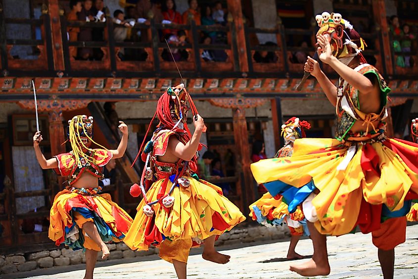 Male dancers performing traditional Bhutanese dance in Mongar, Bhutan. Image Credit Lakkana Savaksuriyawong via Shutterstock.