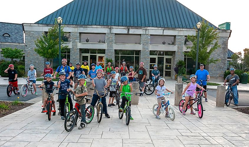 Berea Pedal with the Police- A group of kids participating in a pedal with the police event posing in front of the Kentucky Artisan Center