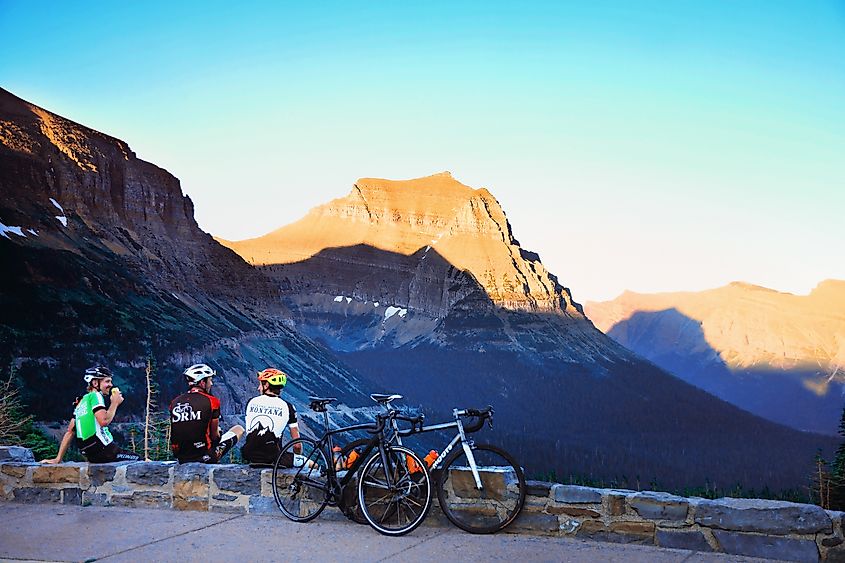 Three cyclists enjoy a beer together after a long ride to the top of Logan Pass in Glacier National Park. Editorial credit: Karin Hildebrand Lau / Shutterstock.com