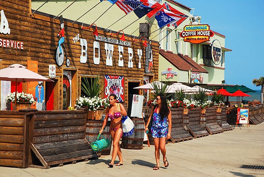 Two women friends walk past the Bowery in Myrtle Beach, SC. Image Credit James Kirkikis via Shutterstock.