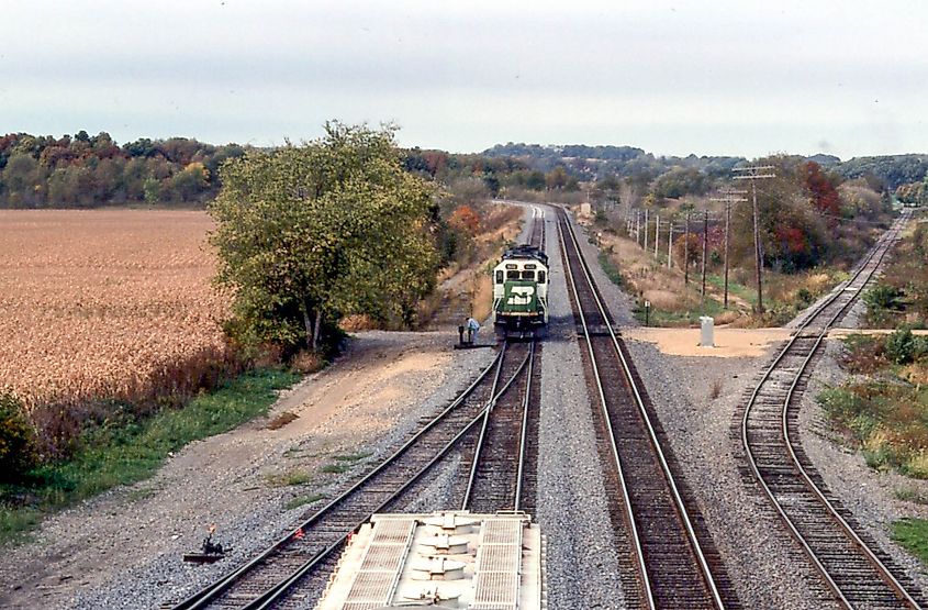 Train passing through Oregon, Illinois, surrounded by fall foliage.