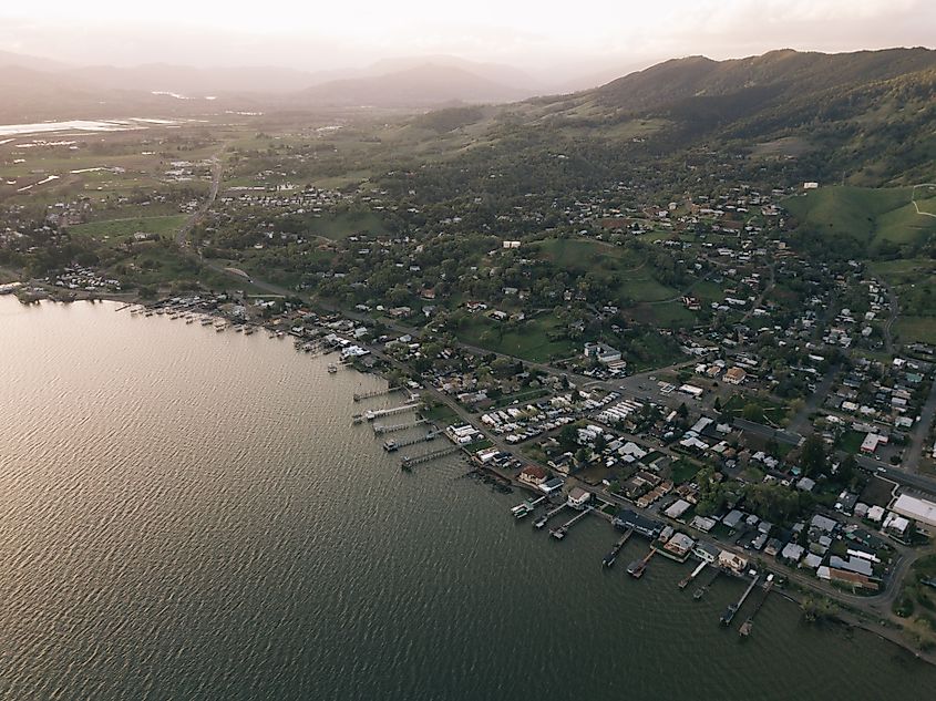 Aerial view of a fisherman fishing at sunset with sunny mountains in Clearlake, California